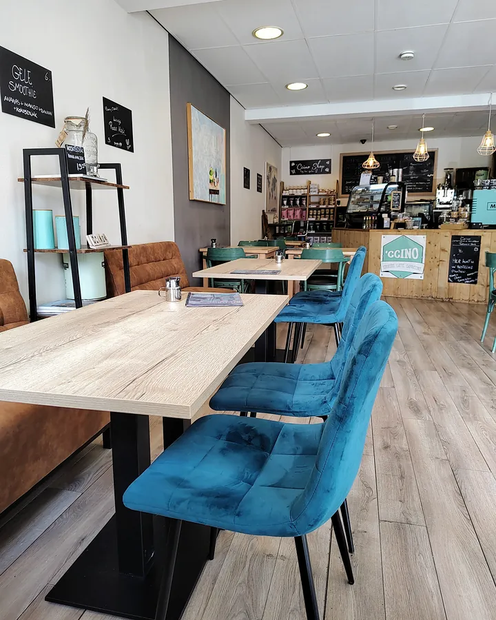Lange tafel met fluwelen stoelen, achterin de bar
