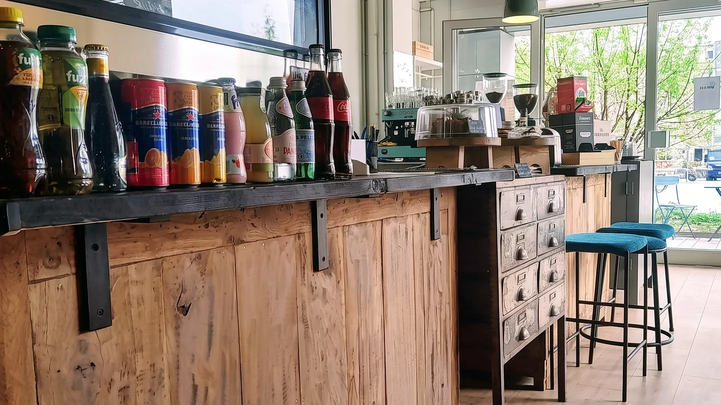 De houten bar met blauwgroene krukken bij 'Ccino Hellevoetsluis
